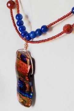 Photo of dichroic glass bead used as a focal bead in a pendant design