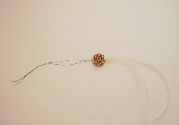 Thread through bead holes and pull ribbon through the bead